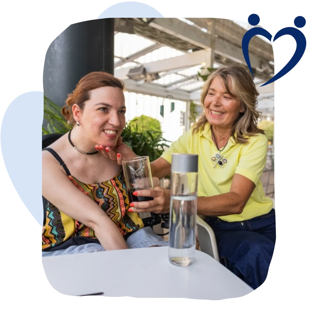 Support worker helping disabled woman have a drink